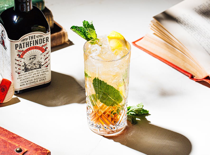 Summer Highball cocktail in a collins glass next to a bottle of The Pathfinder spirit